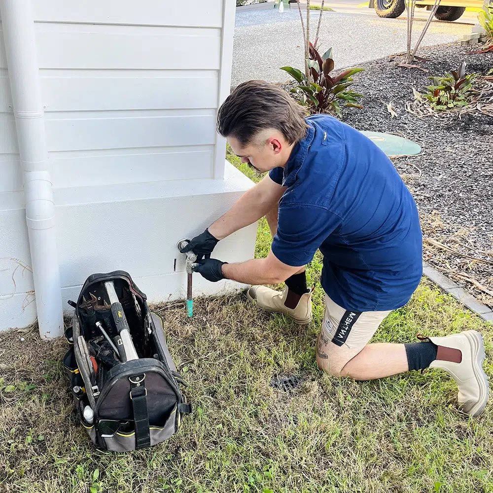 Qualified Plumber outside a home closing the main gas shut-off valve prior to maintenance. High Tide Plumbing on the Gold Coast