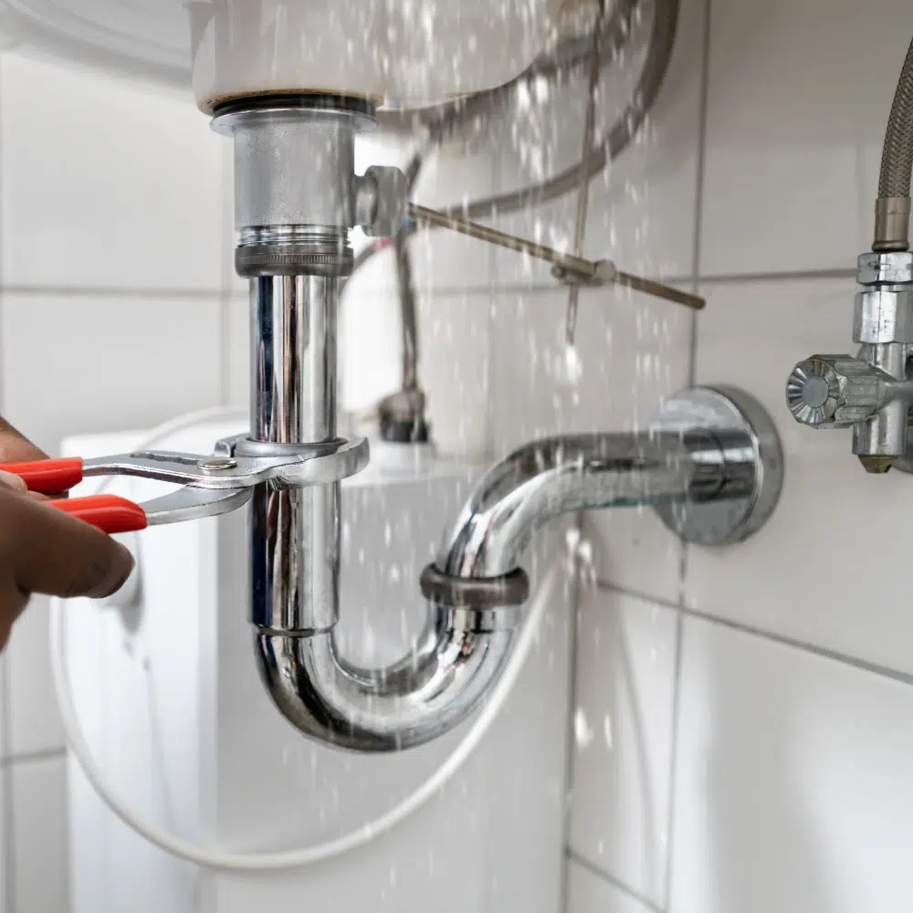 An experienced and licenced plumber under a kitchen sink providing Professional Pipe Leak Services across the Gold Coast