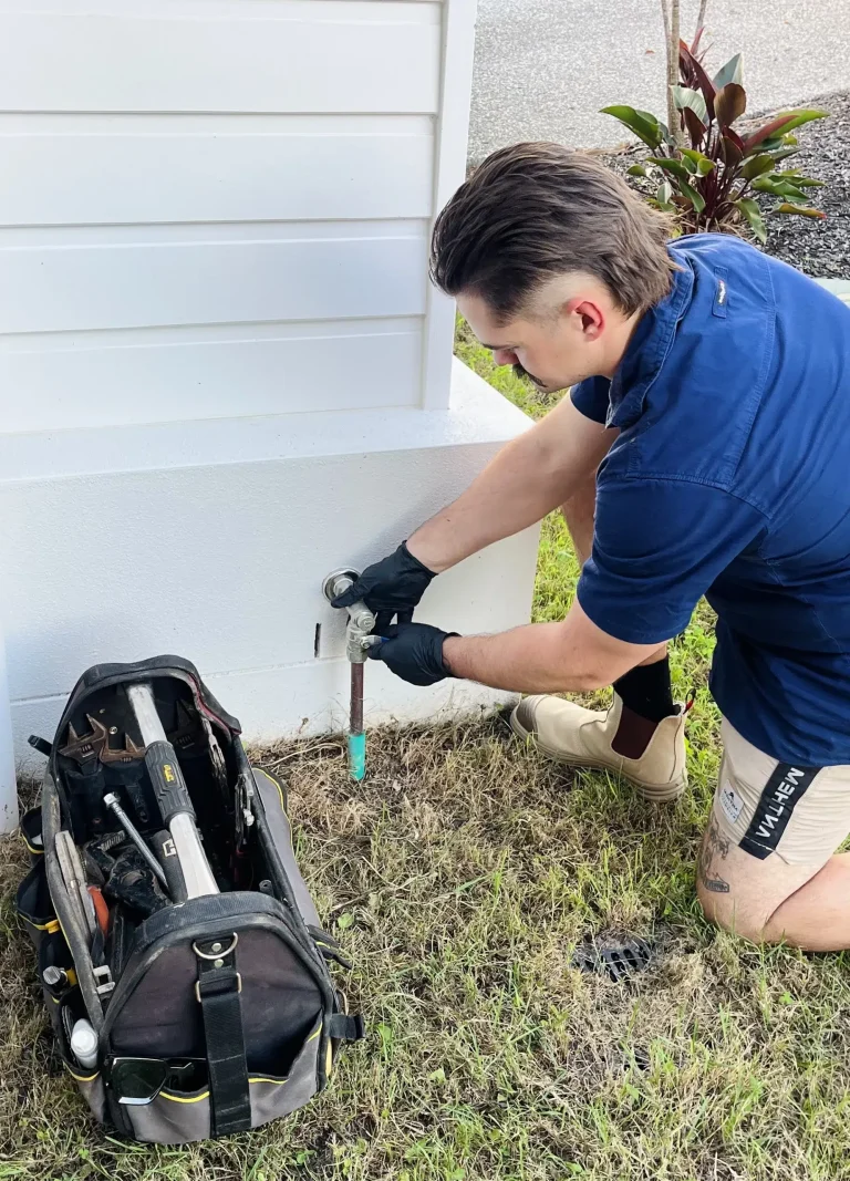Qualified Plumber outside a home closing the main gas shut-off valve prior to maintenance. High Tide Plumbing on the Gold Coast
