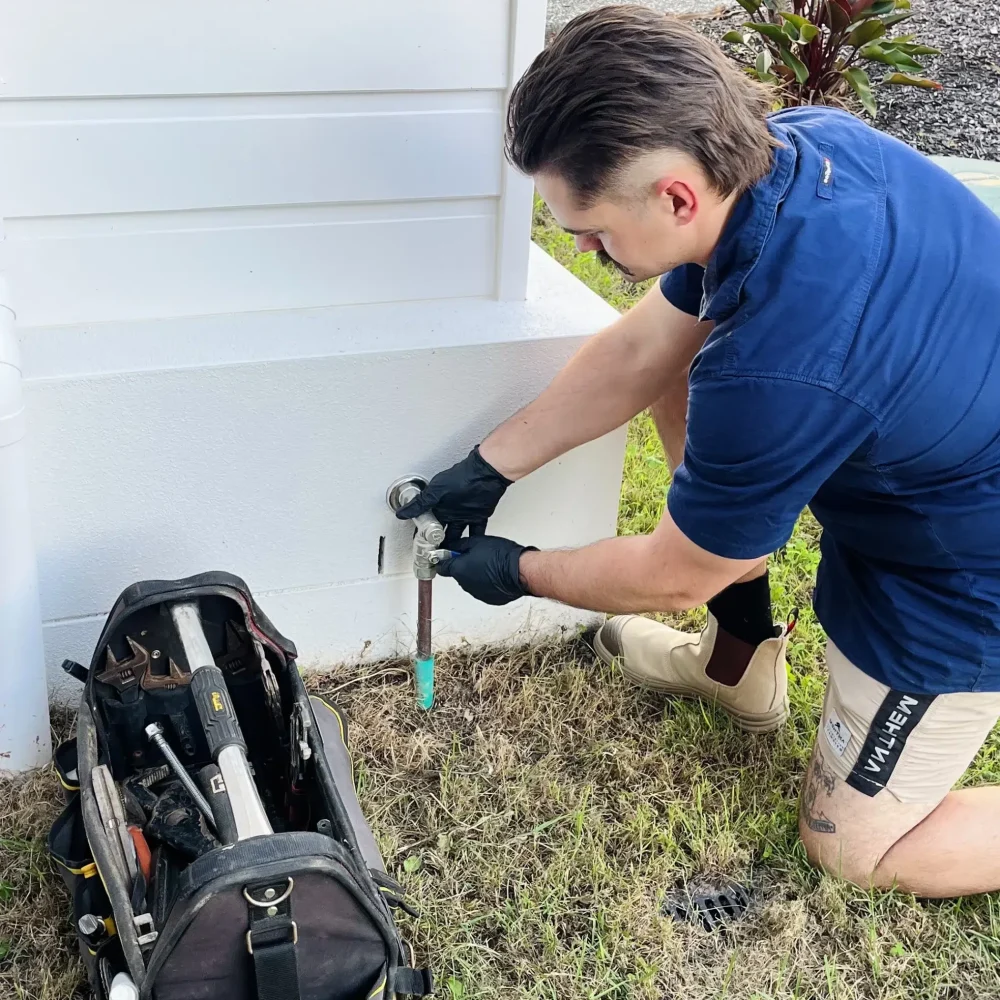 Qualified Plumber outside a home closing the main gas shut-off valve prior to maintenance. High Tide Plumbing on the Gold Coast