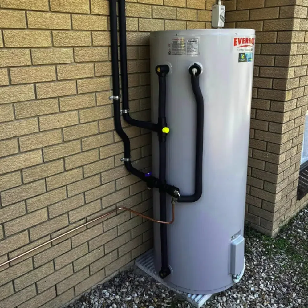 Grey Gas Hot water service on a steel grate outside a house. High Tide Plumbing & Gas